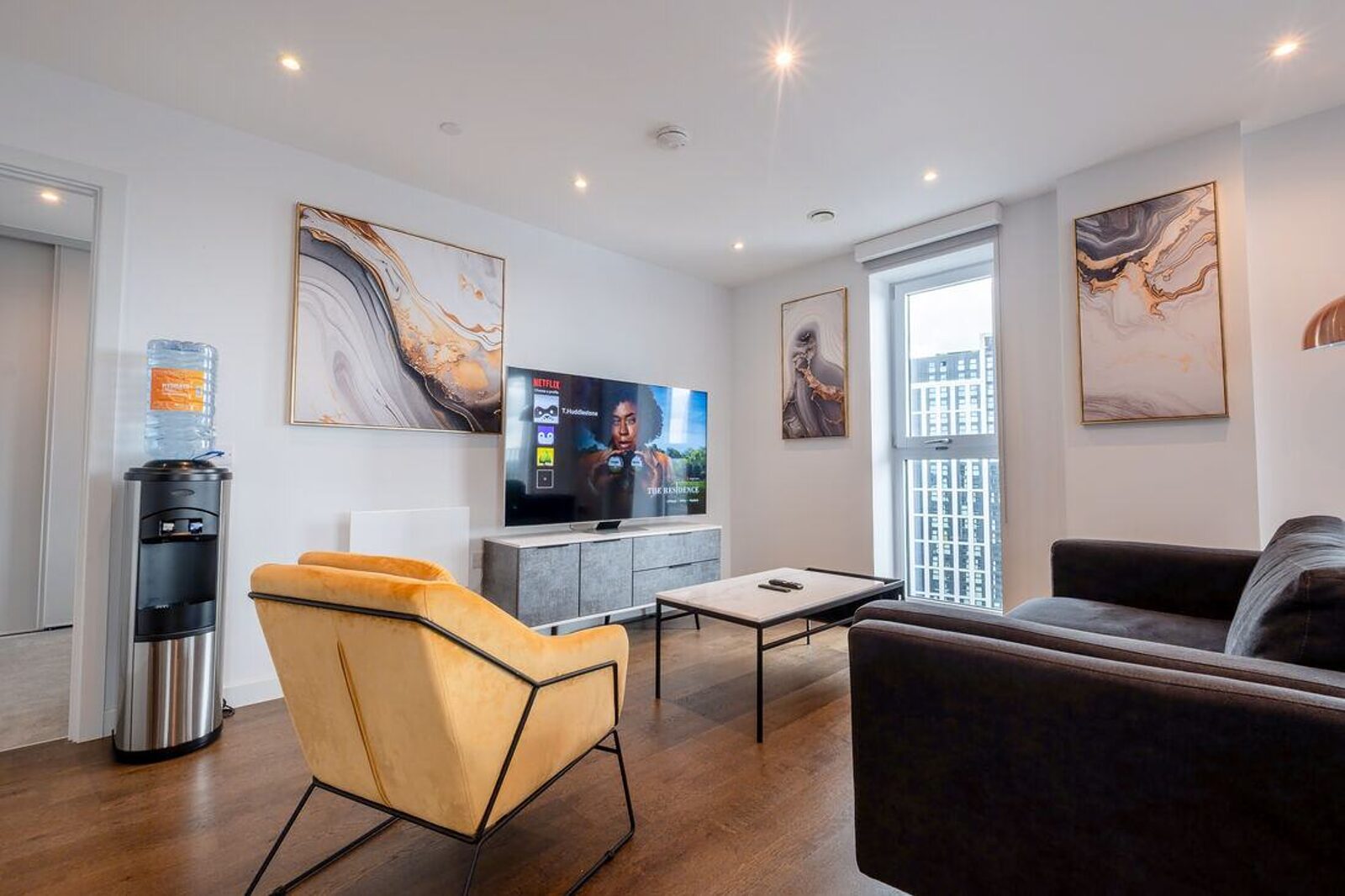 A city centre apartment living room with a full-height window looking out over neighbouring buildings.